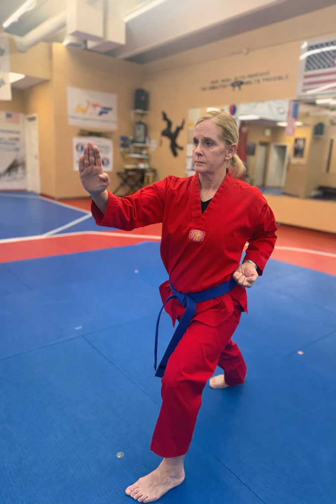 Black belt student practicing kick technique in the dojang